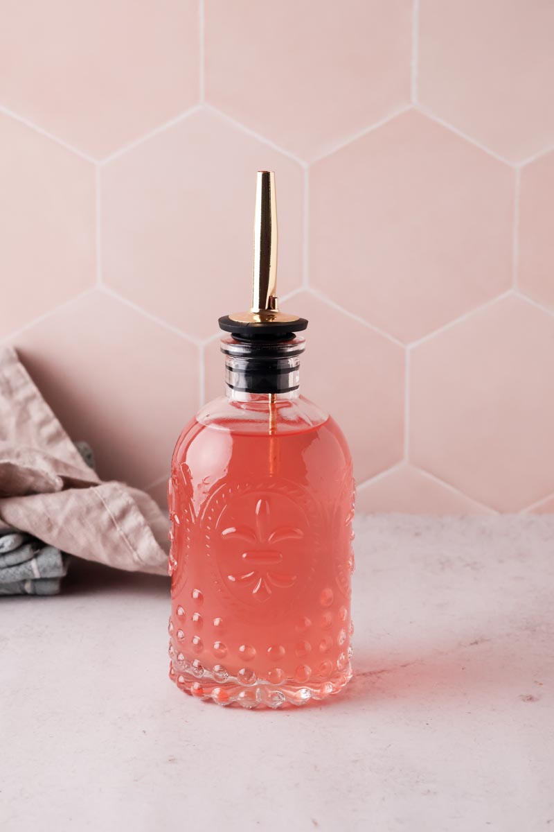 peach simple syrup in glass bottle