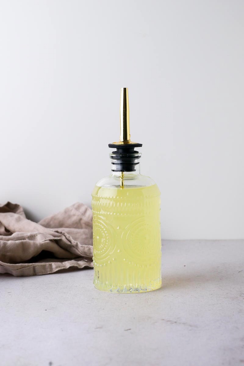 close up of lemon simple syrup with grey background