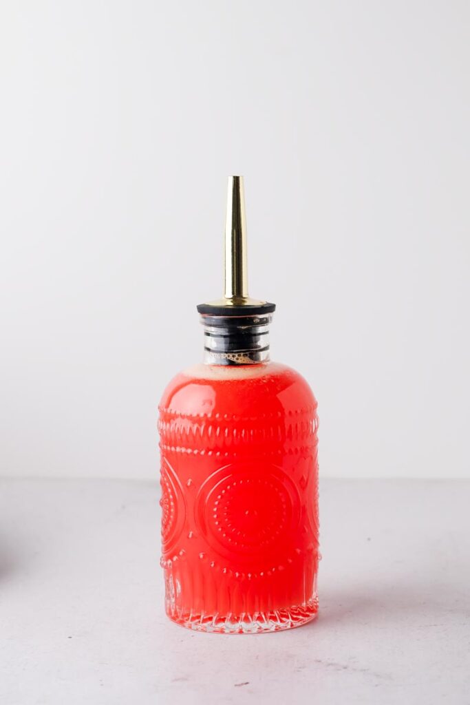 blood orange simple syrup in syrup bottle