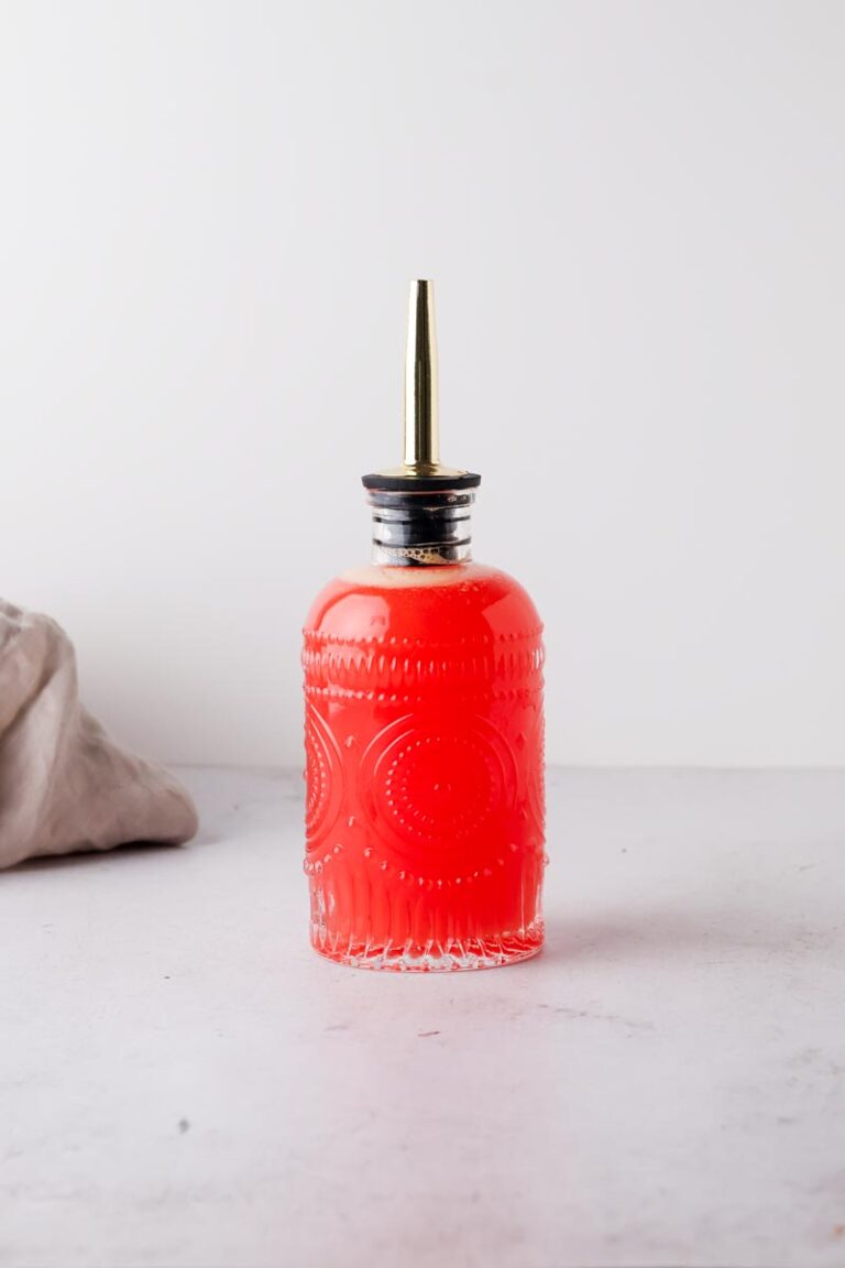 blood orange simple syrup in a glass bottle