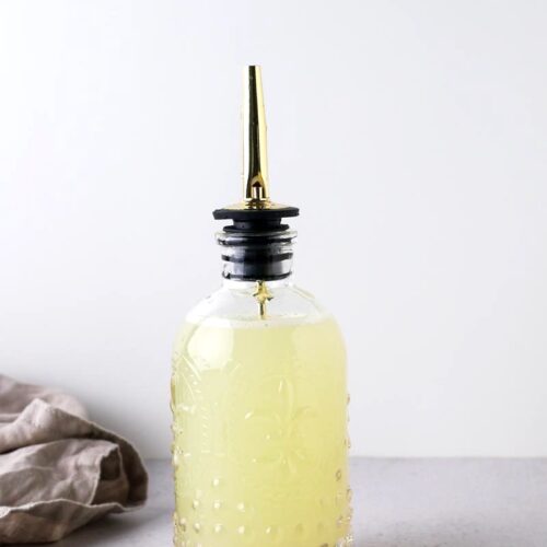 lime simple syrup in glass bottle