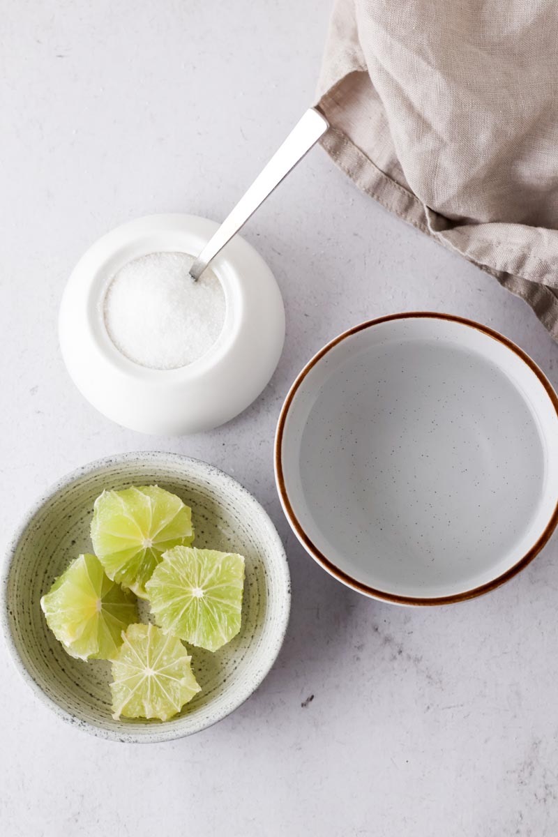 lime chunks, sugar and water on a table