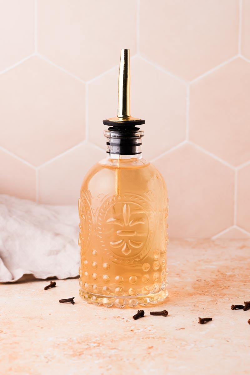 freshly made clove simple syrup in a bottle