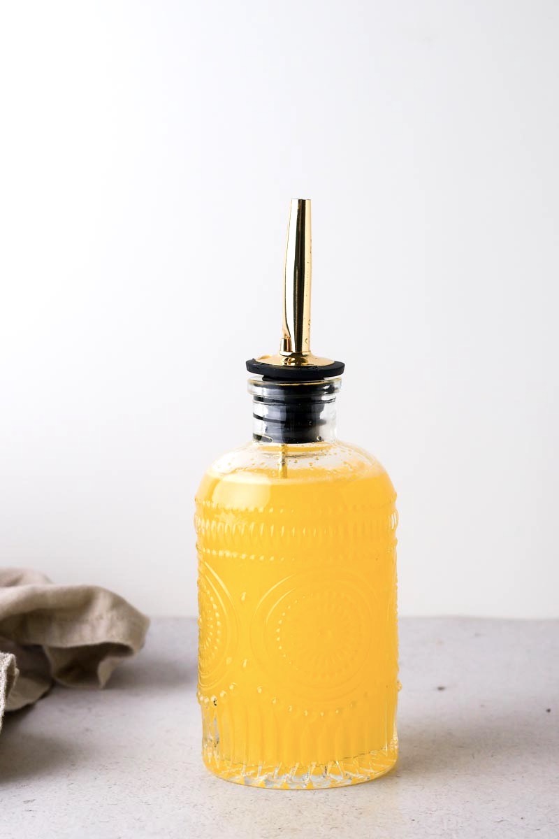 orange simple syrup in syrup bottle