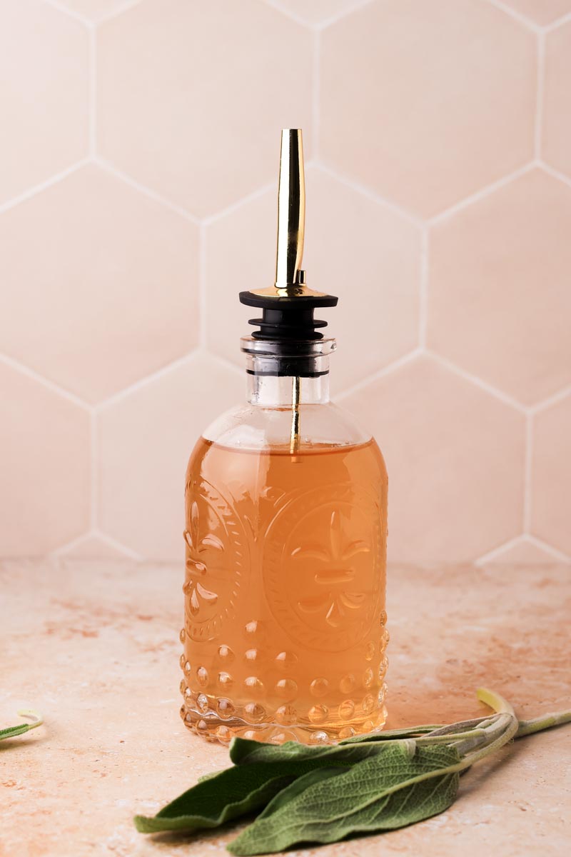 sage simple syrup in a syrup bottle