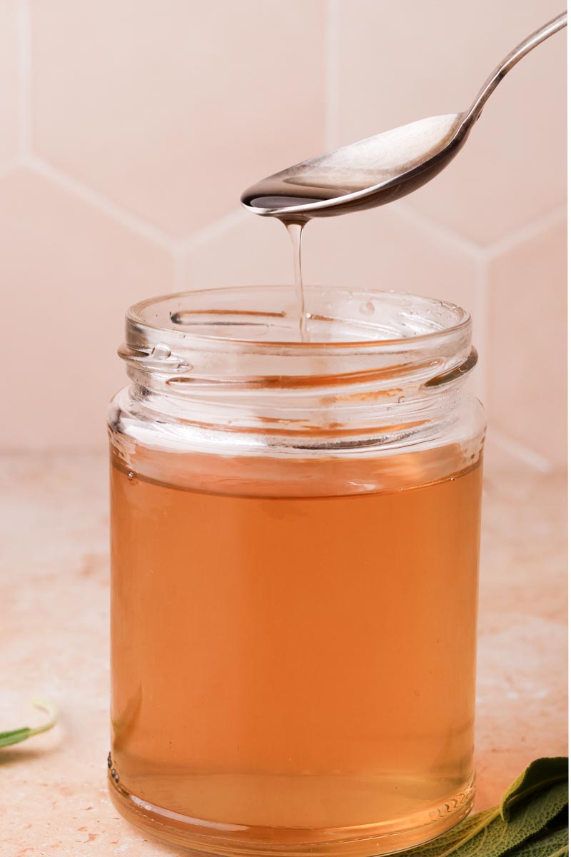 a teaspoon of sage simple syrup from a jar