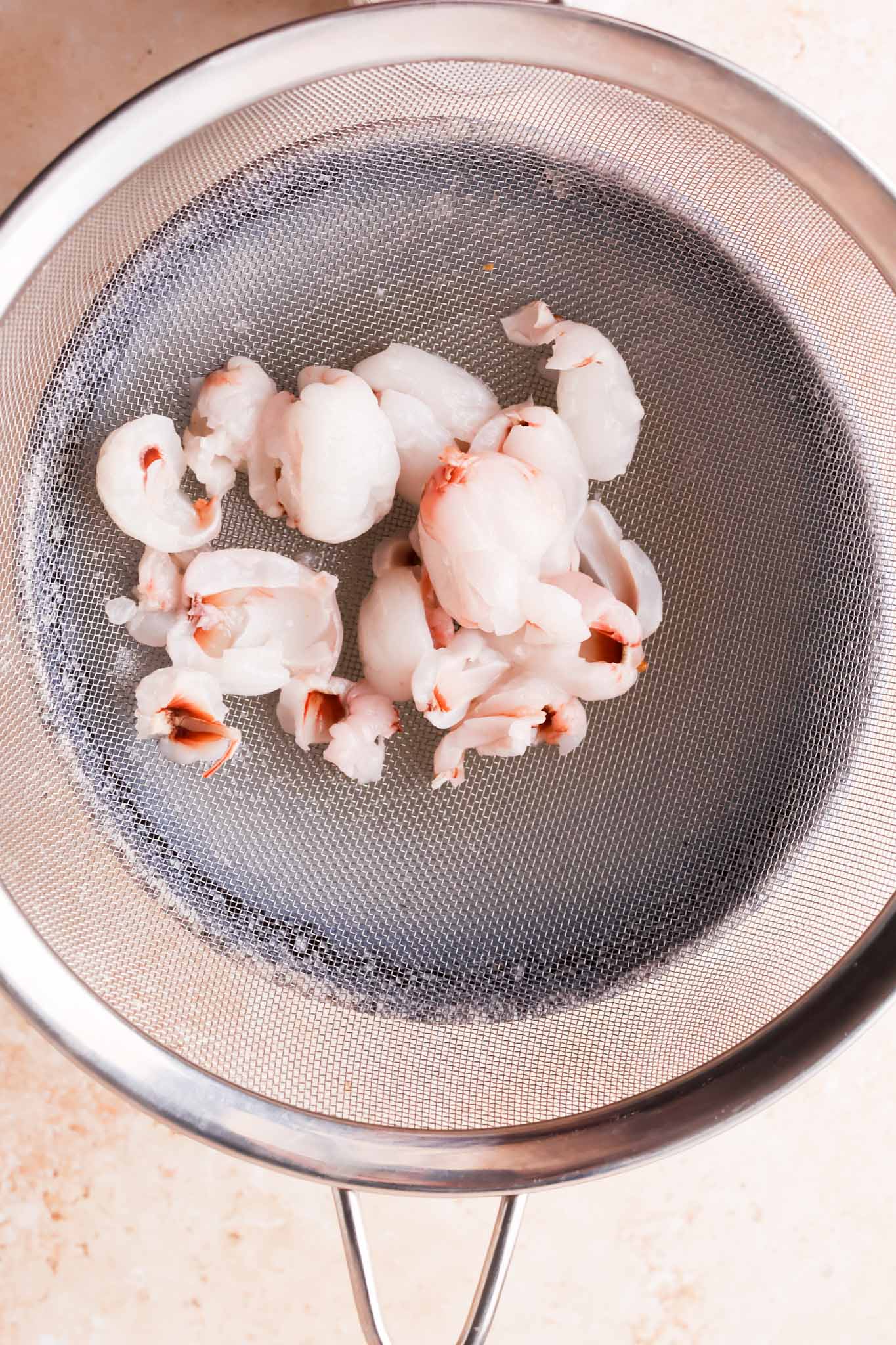 lychees in a sieve on top of a bowl