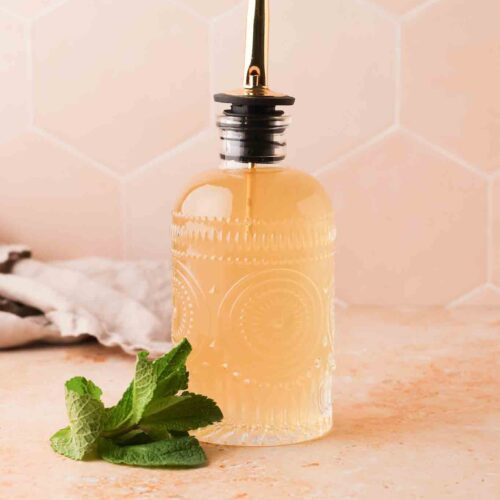 homemade mint simple syrup in a glass bottle