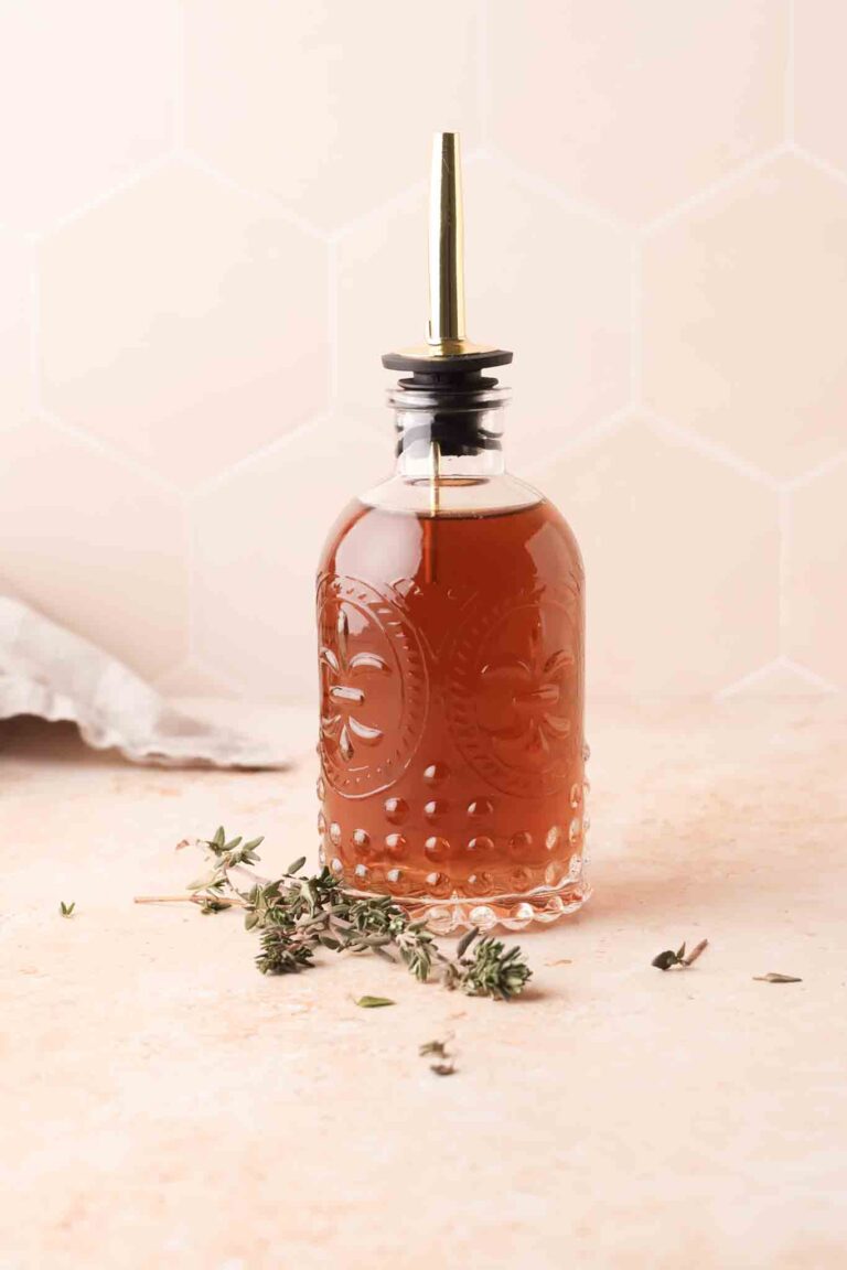 thyme simple syrup in a bottle set on a table