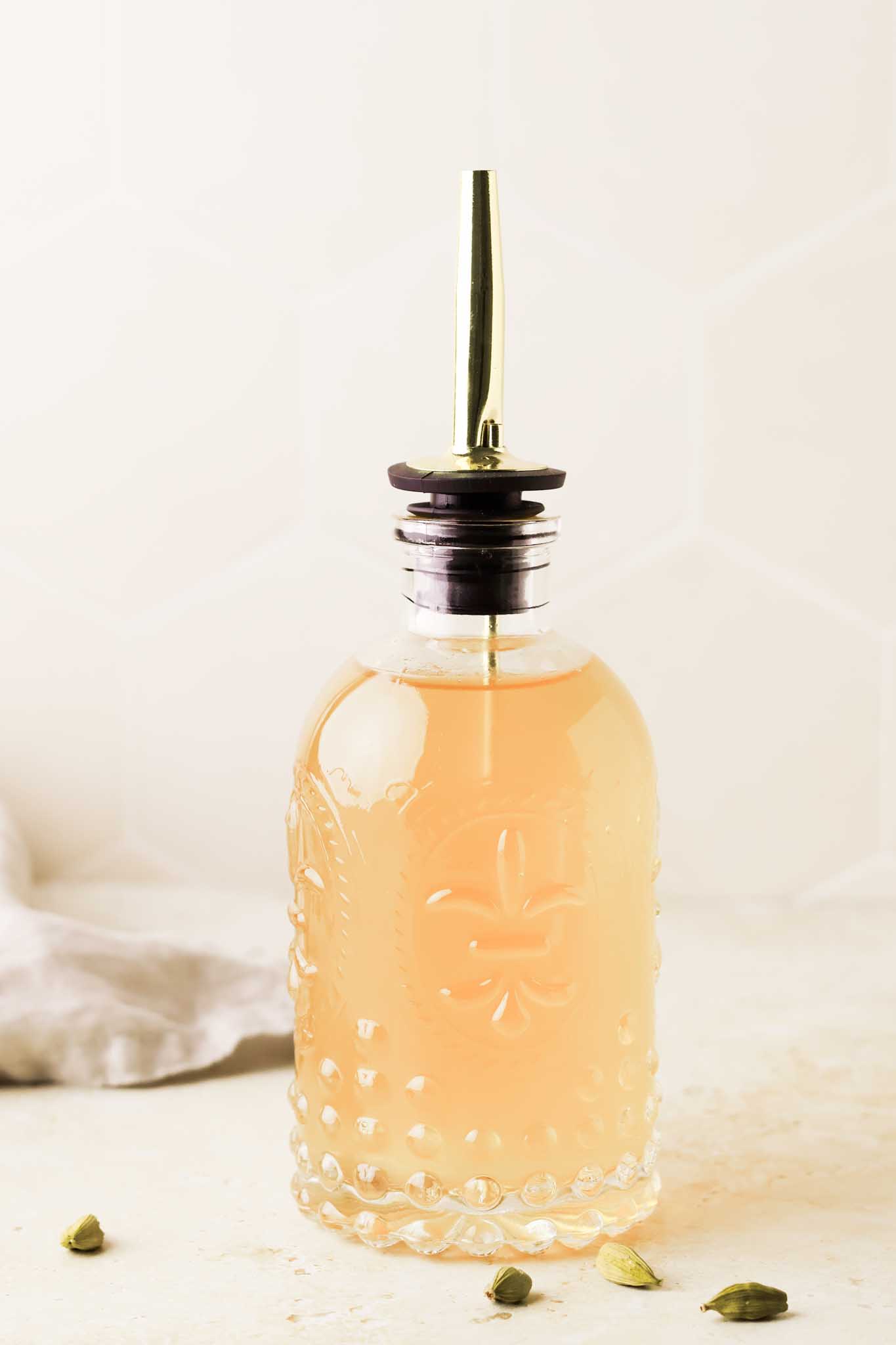 of close up cardamom simple syrup in a bottle