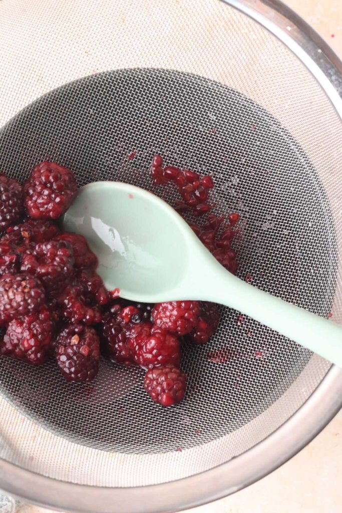 blackberry simple syrup straining in seive