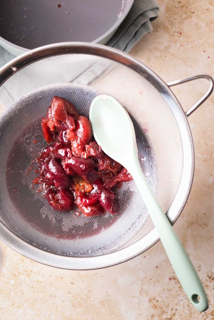 simmered cherries in a sieve