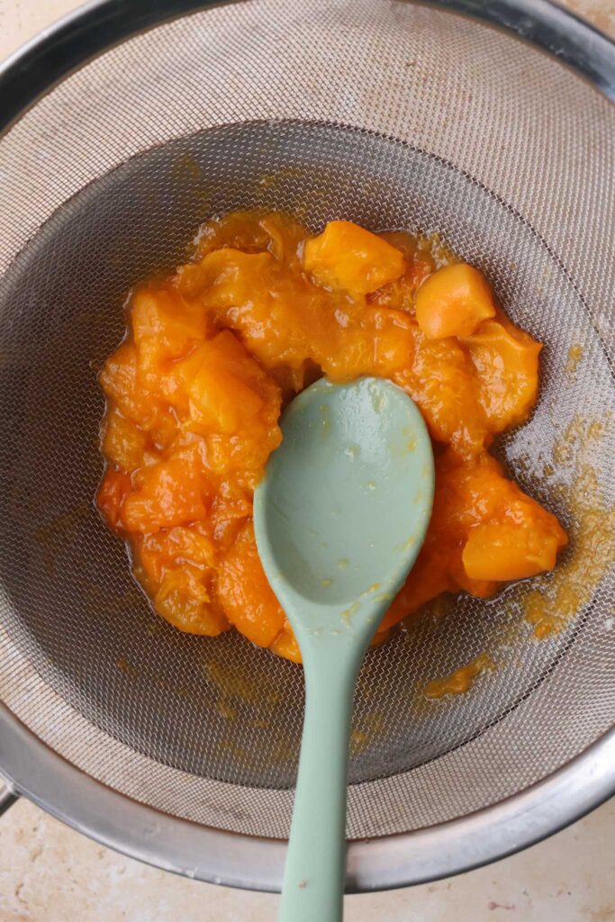 cooked apricots draining in sieve