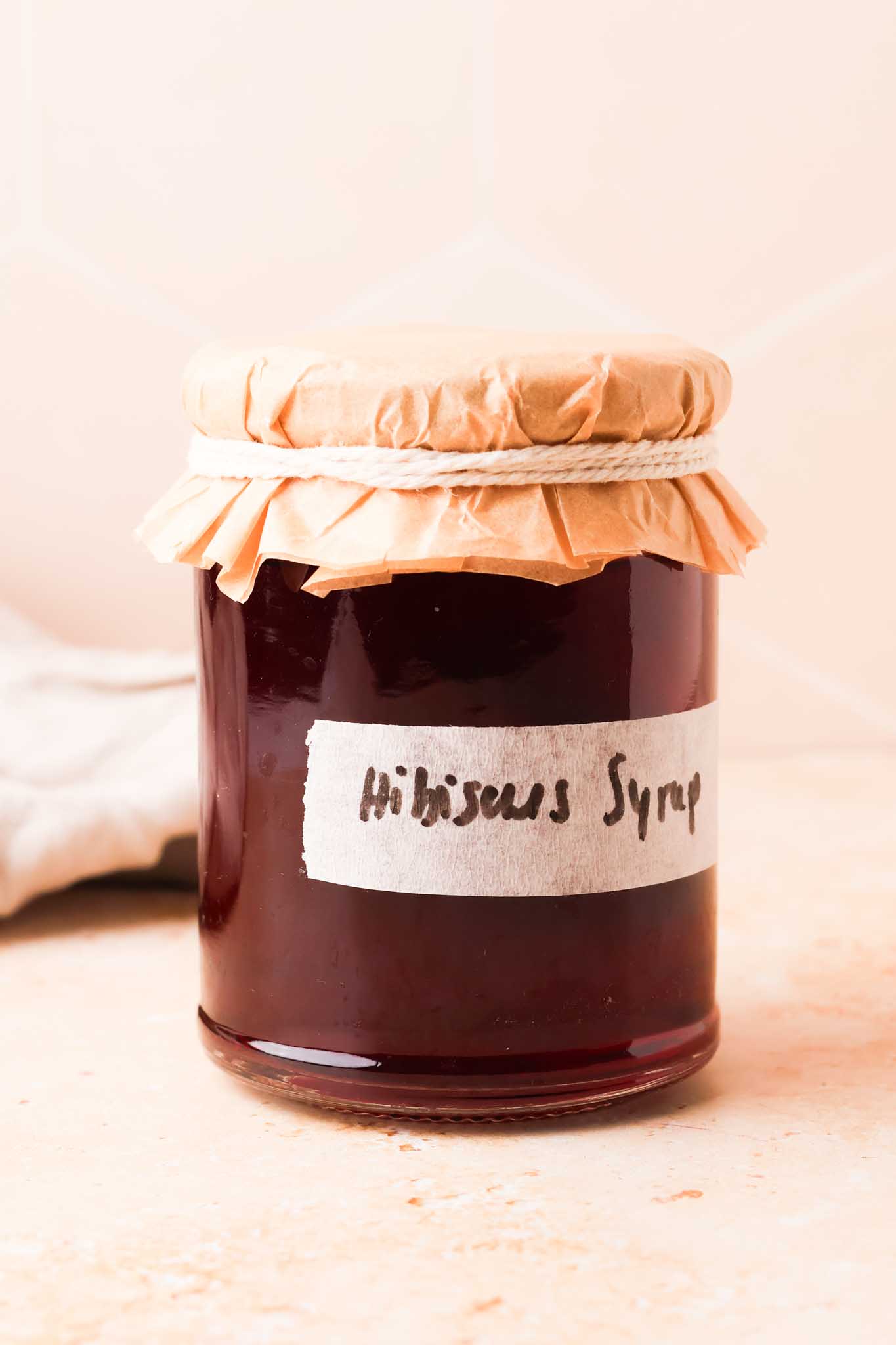 hibiscus simple syrup in jar with a label