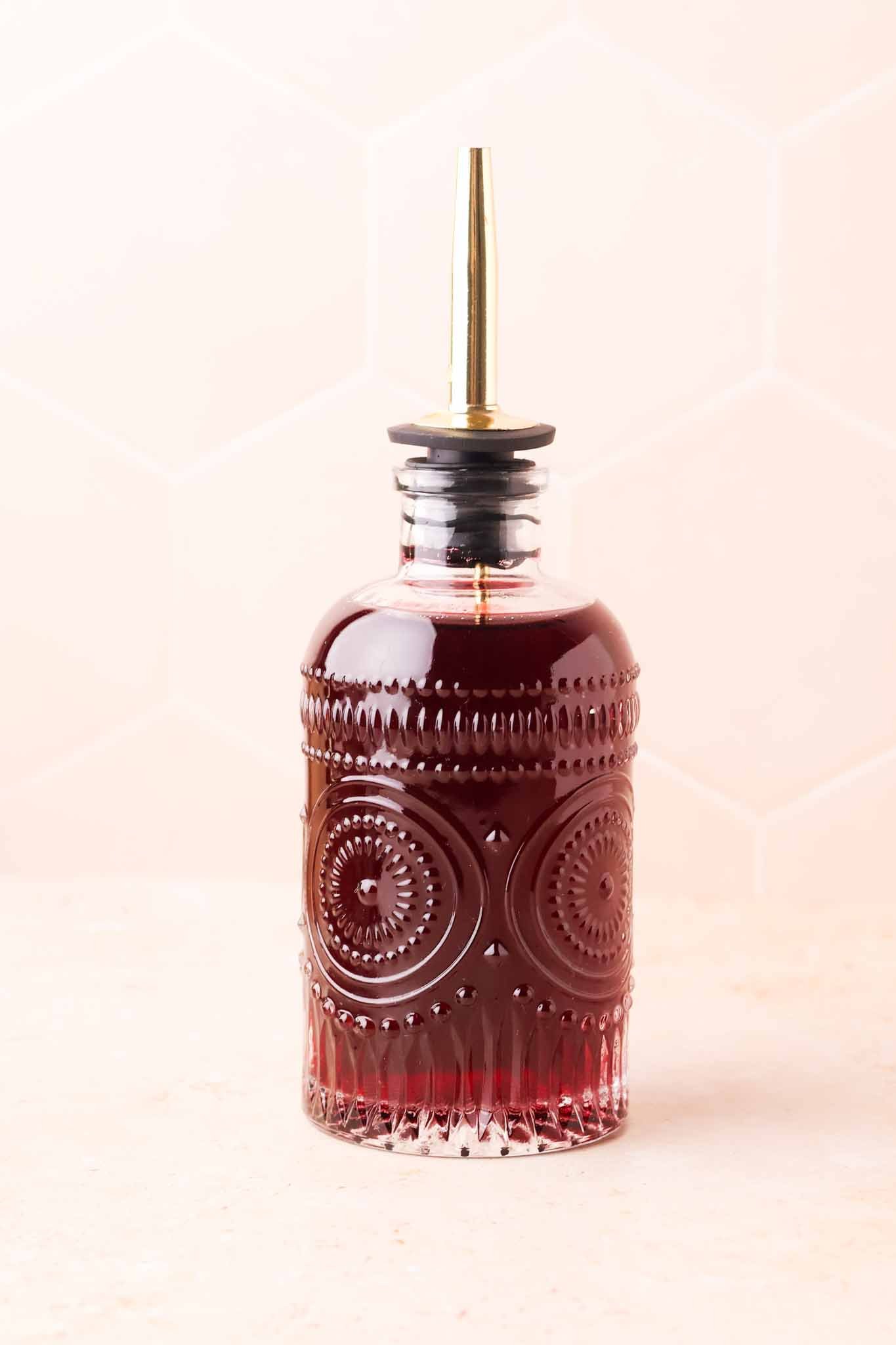 close-up of grape syrup in a transparent glass bottle