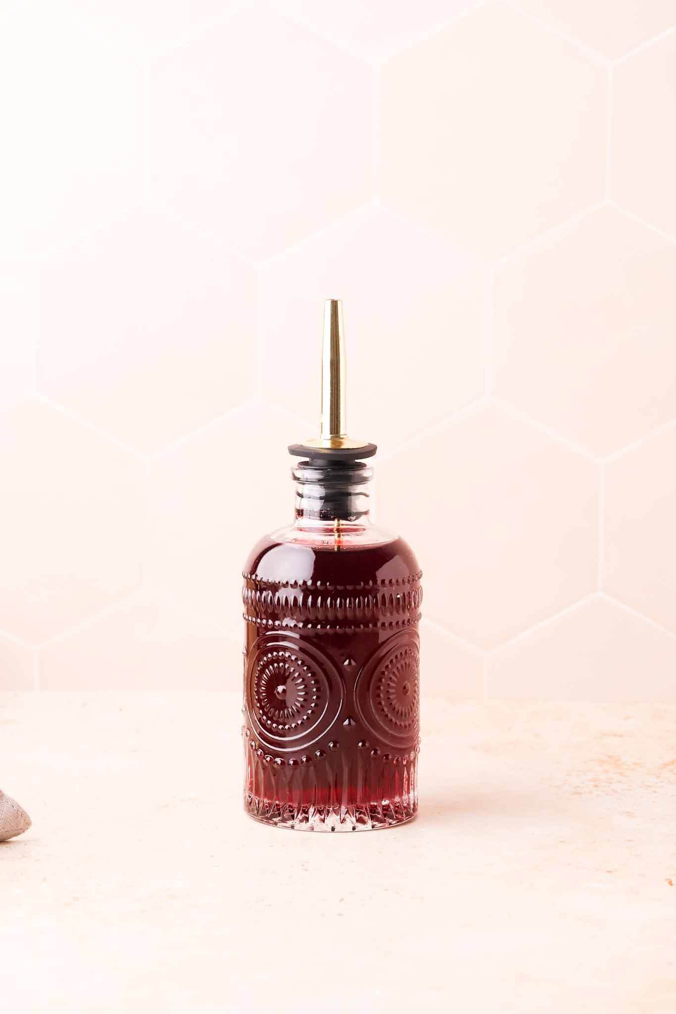 bottle of rich purple grape syrup on a kitchen counter