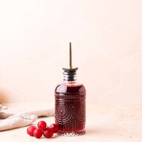 homemade grape syrup in a clear glass bottle