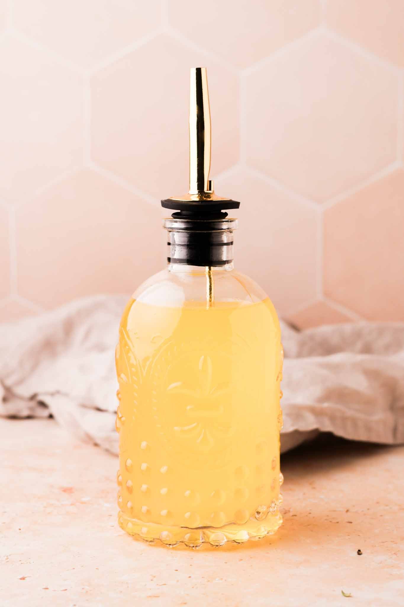 a close up of orange blossom simple syrup with napkin in the background